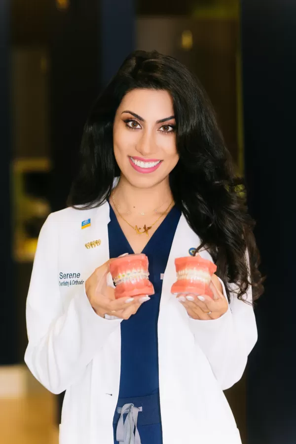 Dr. Mana Naeim holding dental models.