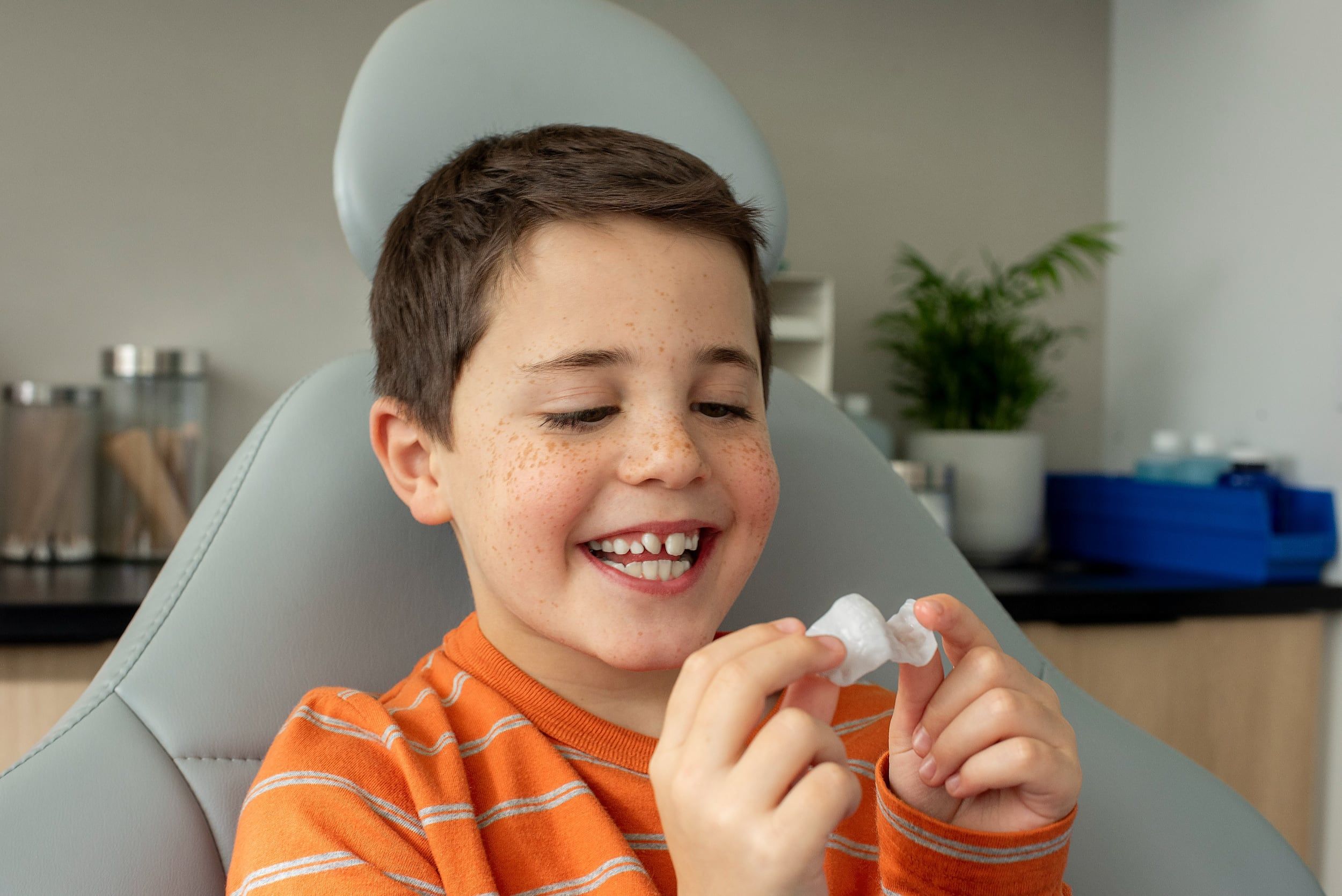 A photo of a young boy holding the Invisalign Palatal Expander in his hands. Dr. Mana Naeim at Serene Orthodontics offers Invisalign palatal expanders, traditional expanders, and removable expanders